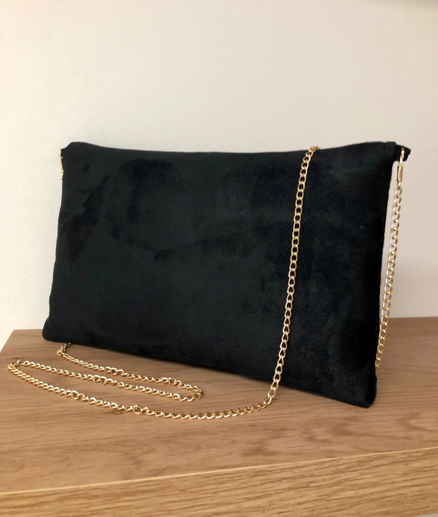 Le dos du sac pochette Isa en suédine noire et paillettes dorées, avec chainette amovible.