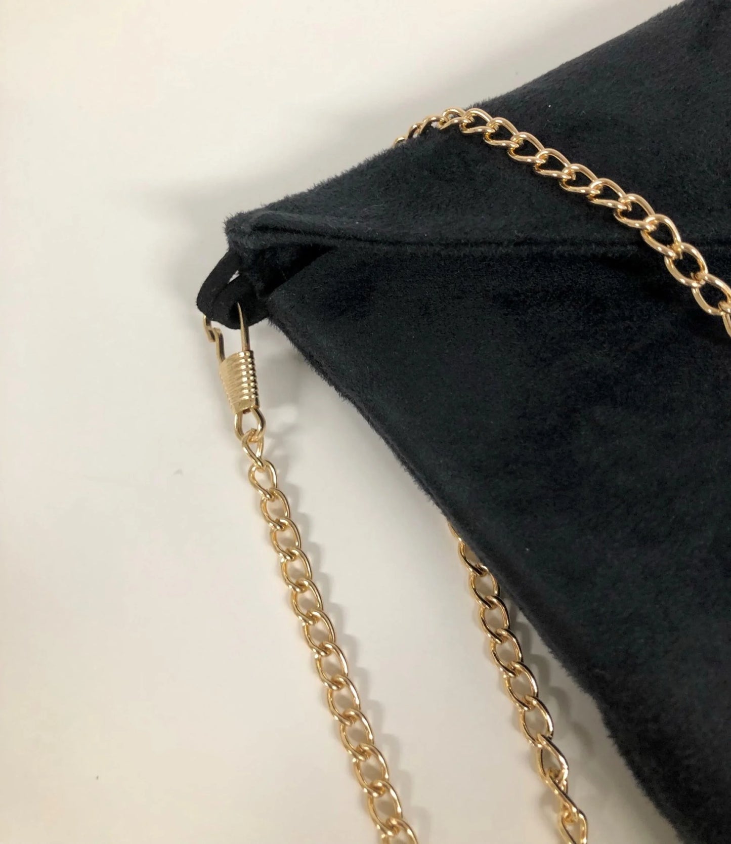 Vue détaillée du sac pochette Isa en suédine noire et paillettes dorées, avec chainette amovible.