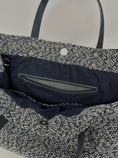 La poche zippée intérieure du sac shopper bleu chiné.