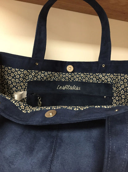 La poche plaquée intérieure du sac Shopper bleu marine .