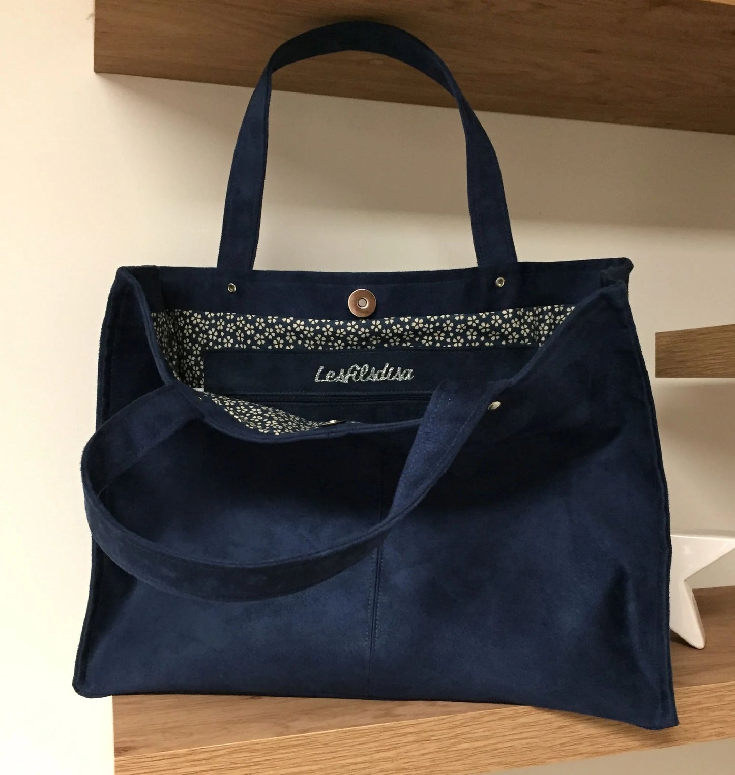 Les anses du sac Shopper bleu marine. 