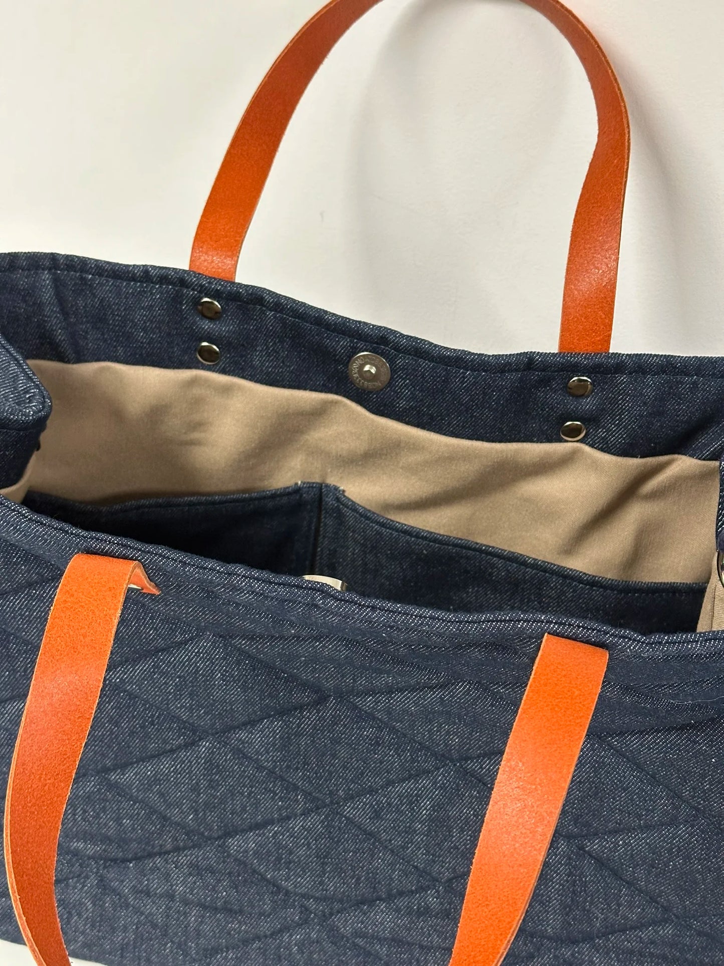 Les deux poches plaquées intérieures du sac Shopper en denim et cuir orange.