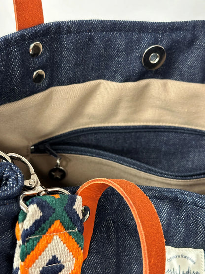 La poche zippée intérieur du sac Shopper en denim et cuir orange.