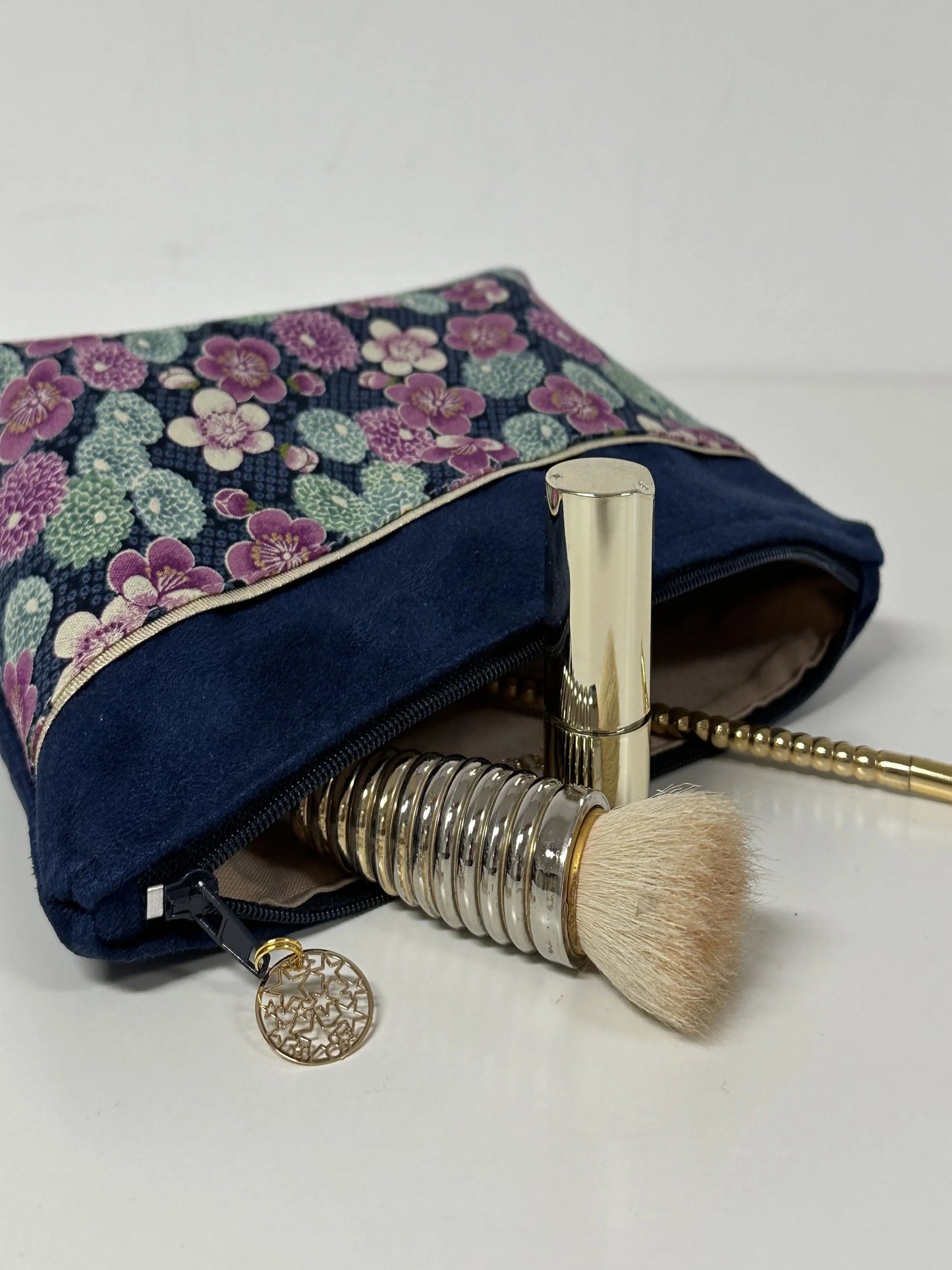 Vue ouverte de la trousse à maquillage bleu marine en tissu japonais à fleurs mauves.