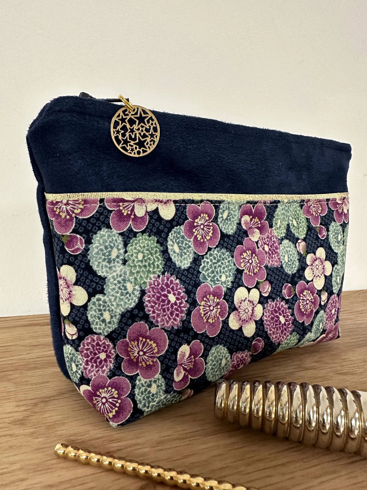 Vue latérale de la trousse à maquilage bleu marine en tissu japonais à fleurs mauves.