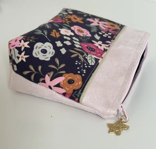 Vue latérale de la trousse à maquillage fleurie rose et bleu.