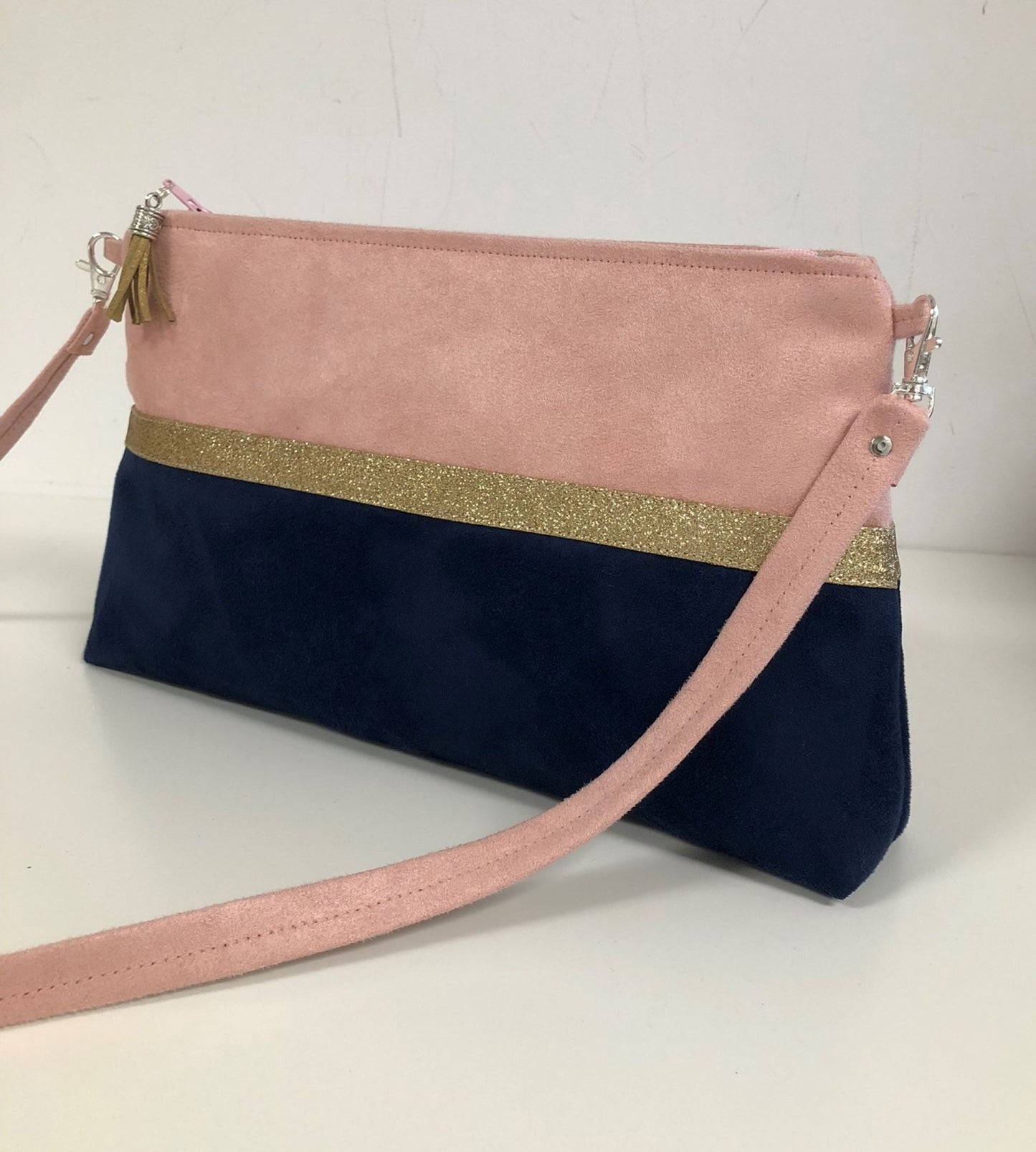 Le sac bandoulière Isa rose poudré et bleu marine à paillettes dorées