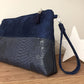La pochette Isa zippée bleu marine aspect reptile avec dragonne amovible