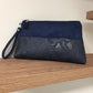 La pochette Isa zippée bleu marine aspect reptile avec dragonne amovible