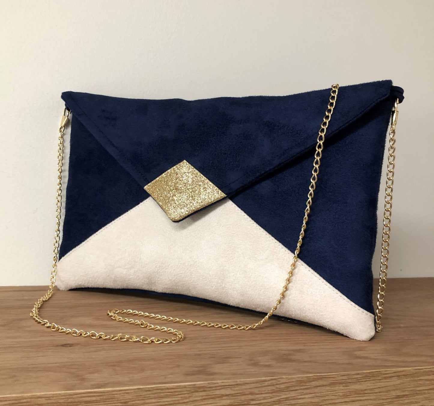 Isa clutch bag in navy blue and ecru with gold sequins