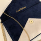 Isa clutch bag in navy blue and ecru with gold sequins