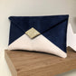 Isa clutch bag in navy blue and ecru with gold sequins