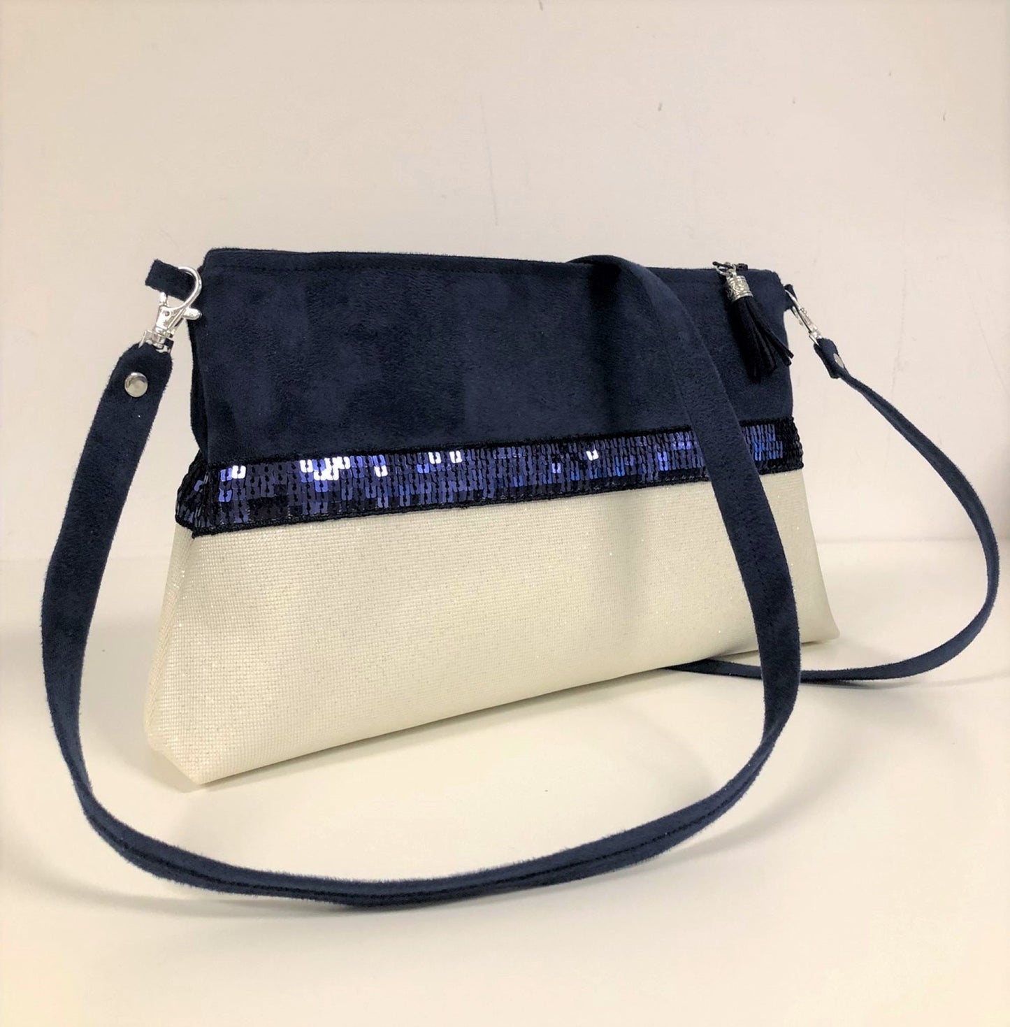 La pochette Isa zippée bleu marine et blanc à paillettes et dragonne amovible