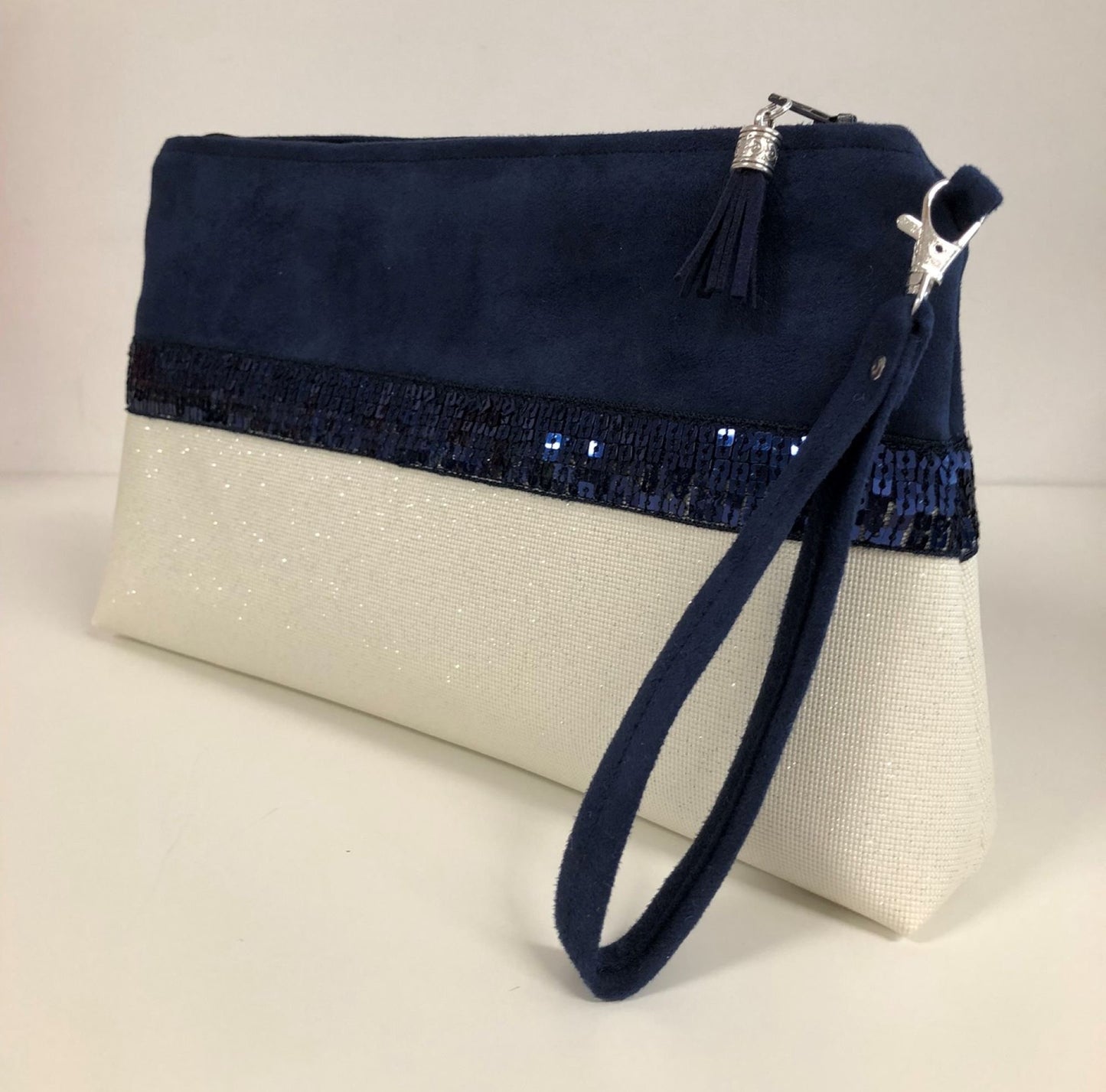 La pochette Isa zippée bleu marine et blanc à paillettes et dragonne amovible