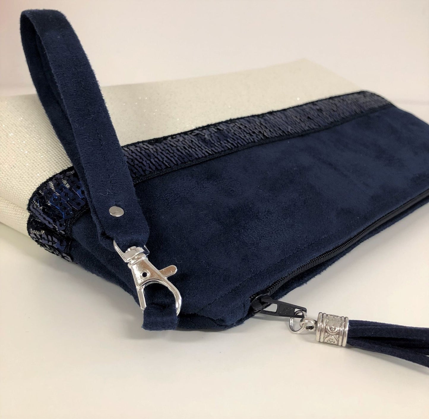 La pochette Isa zippée bleu marine et blanc à paillettes et dragonne amovible