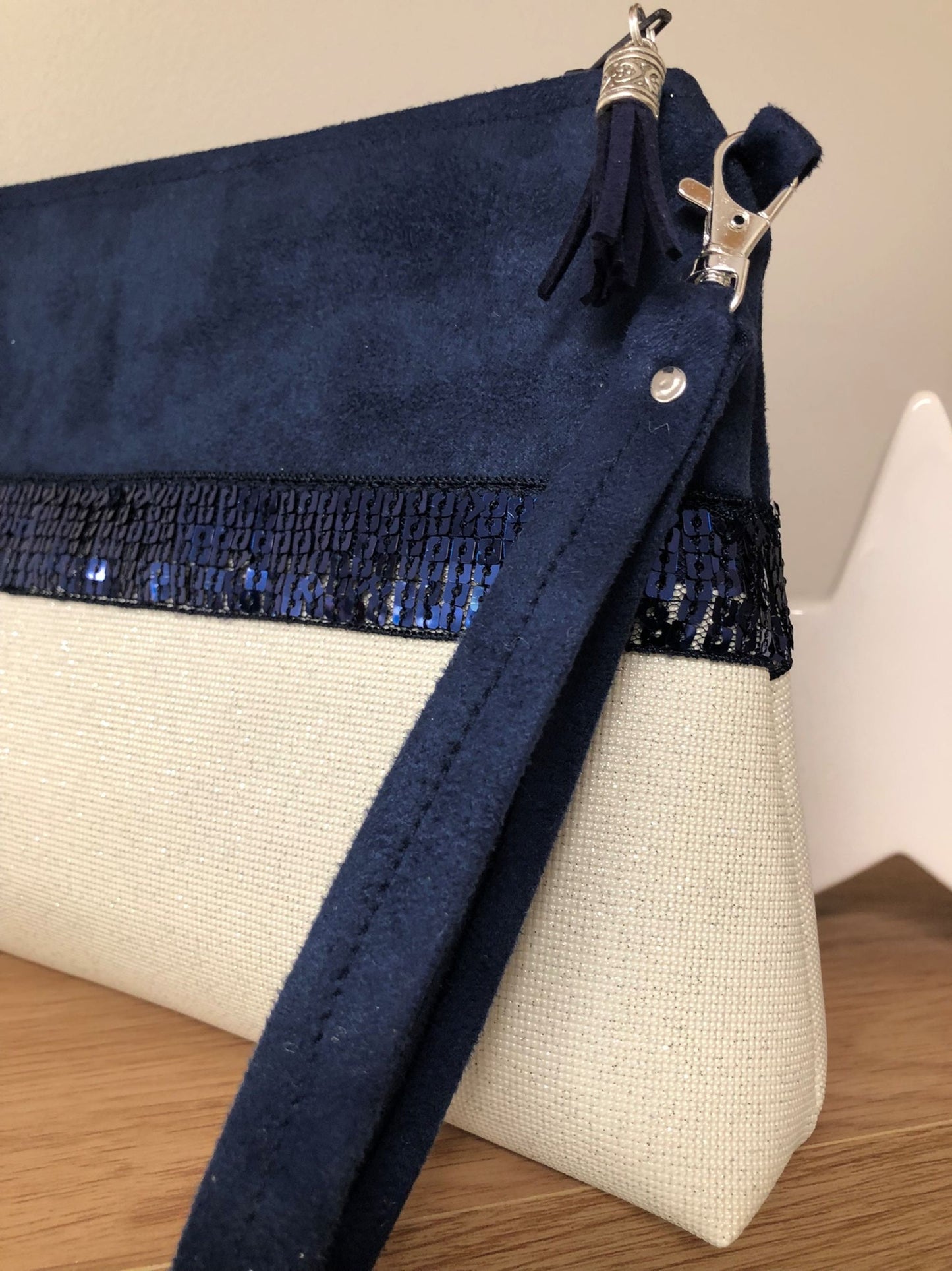 La pochette Isa zippée bleu marine et blanc à paillettes et dragonne amovible