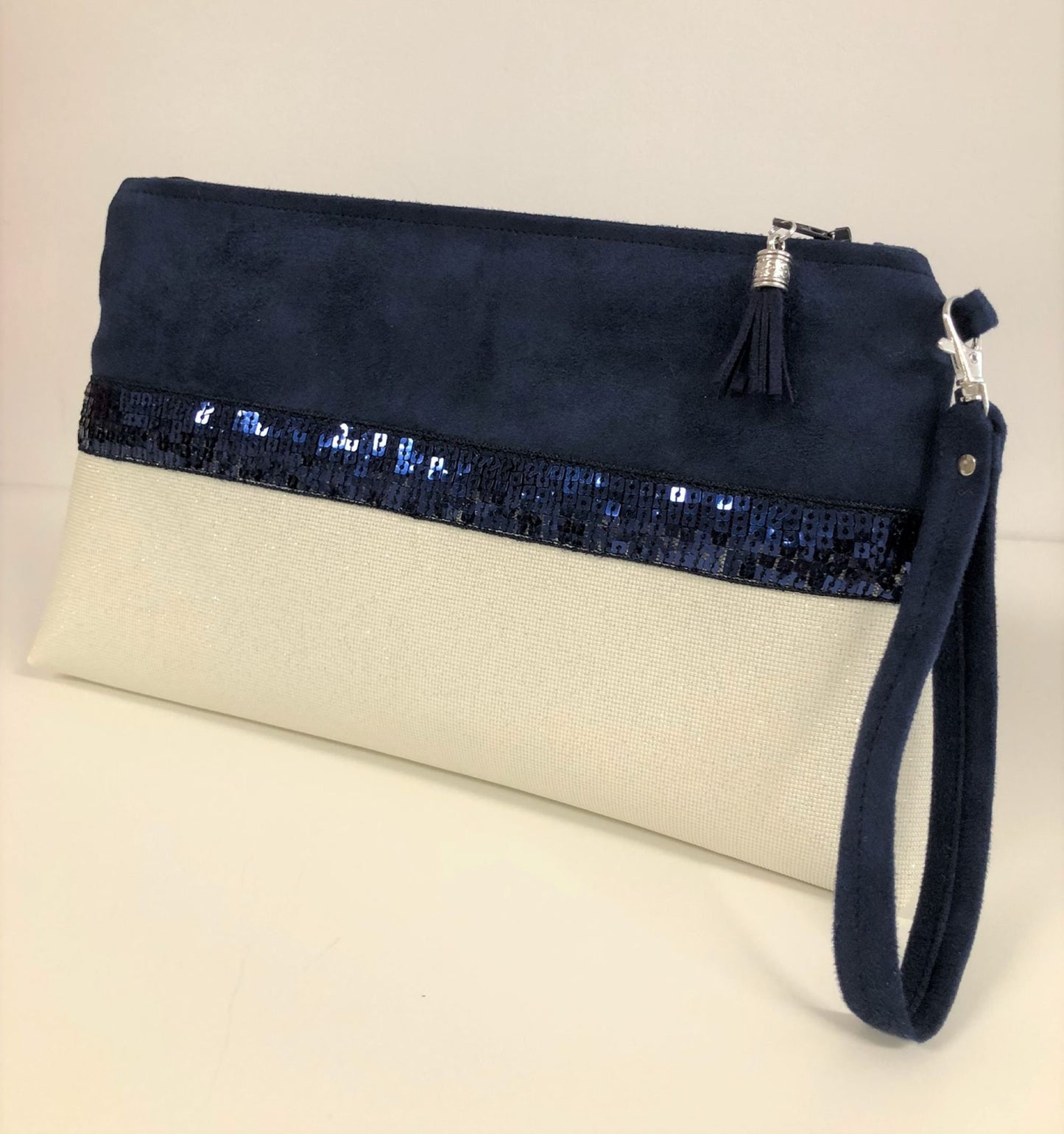 La pochette Isa zippée bleu marine et blanc à paillettes et dragonne amovible